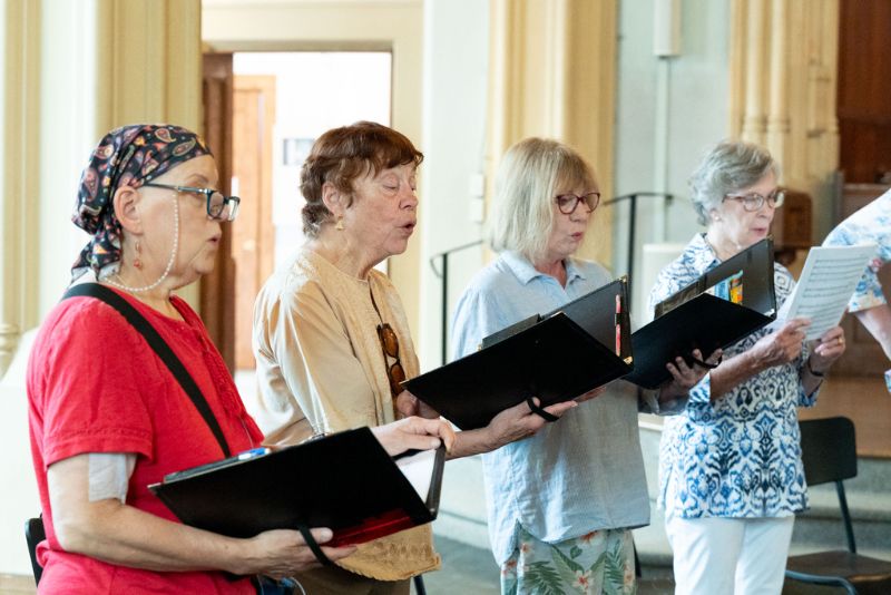 Choir members singing during practice.