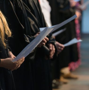 Choir members performing and holding choir song books.